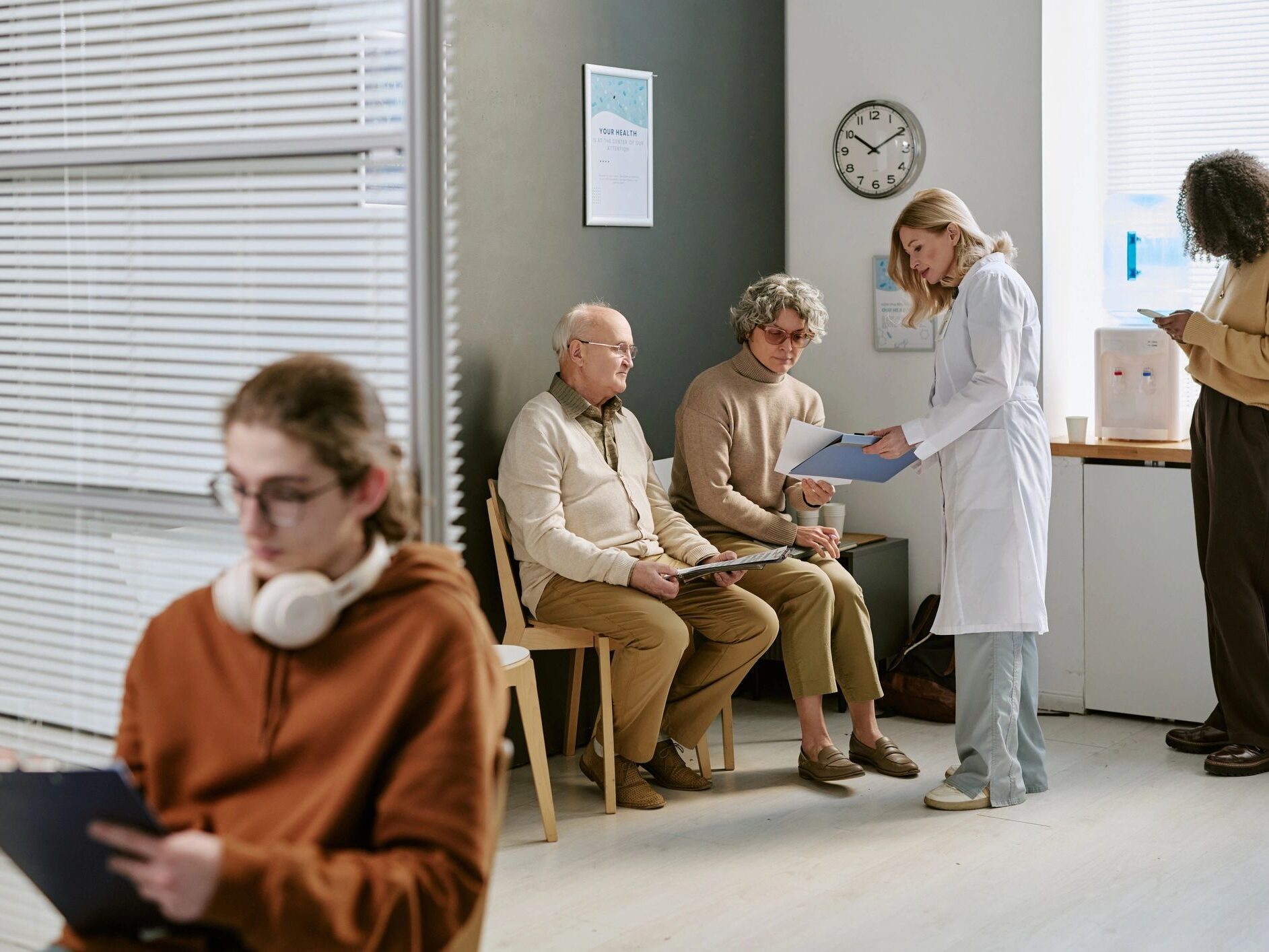 Doctor Consulting Senior Patients in Clinic Waiting Room