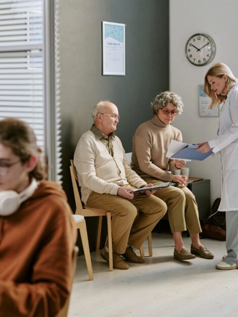 Doctor Consulting Senior Patients in Clinic Waiting Room