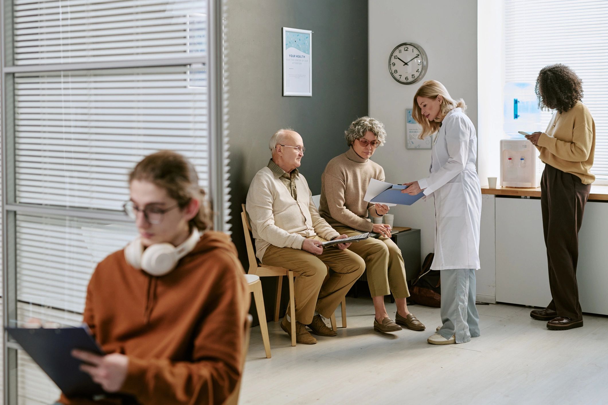 Doctor Consulting Senior Patients in Clinic Waiting Room